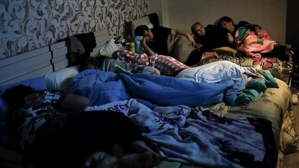 Люди смотрят телевизор в бомбоубежище в Степанакерте