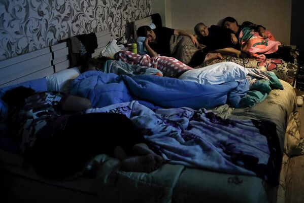 Люди смотрят телевизор в бомбоубежище в Степанакерте
