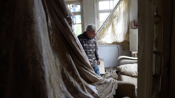 Местный житель показывает комнату пострадавшего после обстрелов дома в городе Мартуни непризнанной Нагорно-Карабахской Республики 