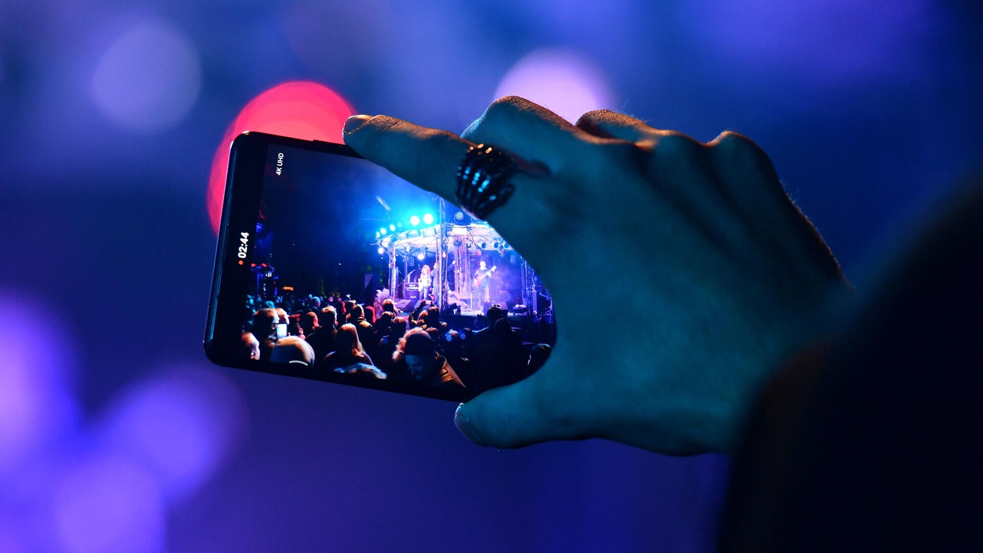 Зритель снимает на мобильный телефон выступление музыкантов на концерте - РИА Новости, 1920, 08.02.2021