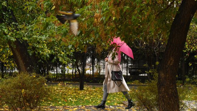 Девушка в сквере во время дождя