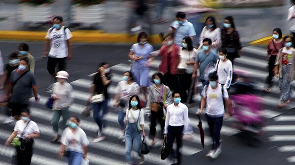 Люди в защитных масках на улице в Шанхае, Китай 