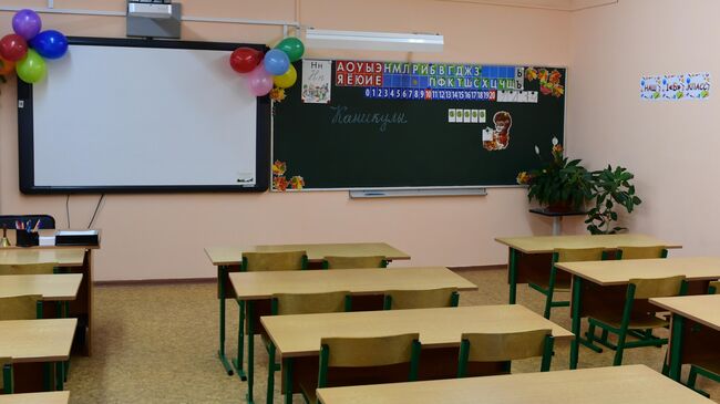 Надпись Каникулы на школьной доске в пустом учебном классе в московской школе