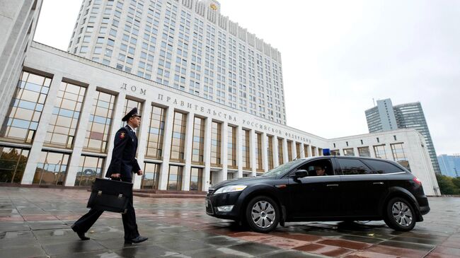 Сотрудник Государственной фельдъегерской службы выносит из здания Дома правительства РФ документы и материалы проекта бюджета