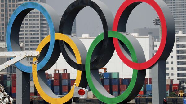 FILE PHOTO: The giant Olympic rings, which are being temporarily removed for maintenance, are seen behind Japan's national flag, amid the coronavirus disease (COVID-19) outbreak, at the waterfront area at Odaiba Marine Park in Tokyo, Japan August 6, 2020. REUTERS/Kim Kyung-Hoon/File Photo