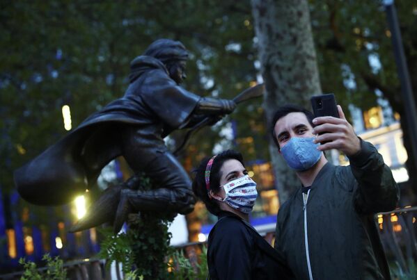 Люди фотографируются возле памятника Гарри Поттеру в Лондоне