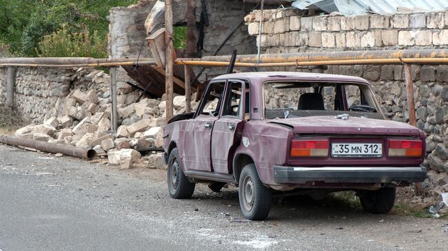 Поврежденный дом и автомобиль в результате обстрелов по общине Иванян Нагорного Карабаха