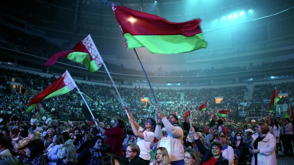 Участники форума в Минске с флагами Белоруссии во время выступления президента Белоруссии Александра Лукашенко