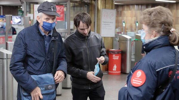 Пассажиры в вестибюле станции метро Пражская в Москве, где проводится проверка масочного режима