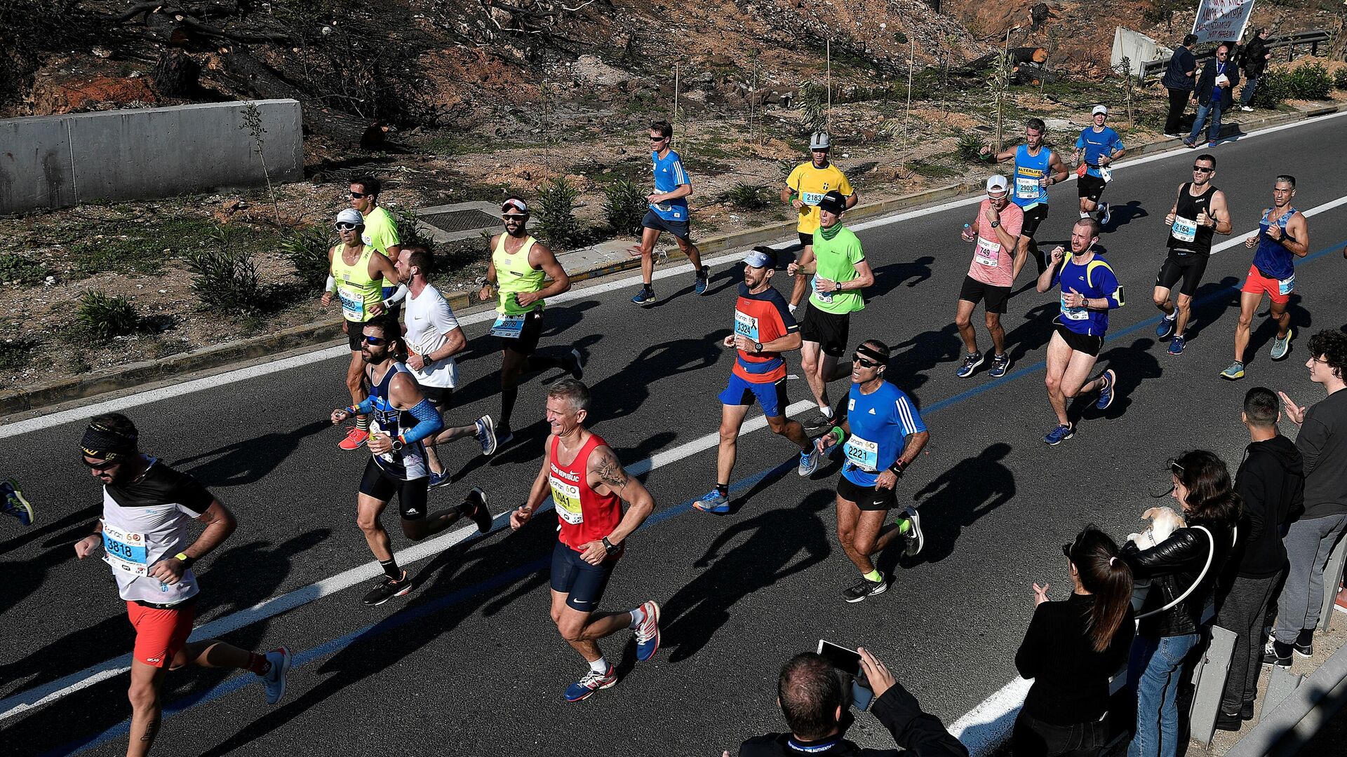 Athletes run past burned out area near the village of Mati during the  36th Athens Classic Marathon 'The authentic' from the town of Marathon to the Panathenaic stadium in Athens on November 11, 2018. (Photo by Louisa GOULIAMAKI / AFP) - РИА Новости, 1920, 02.10.2020