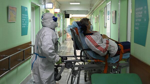 Медицинский работник во время транспортировки больного в палату госпиталя COVID-19 городской клинической больницы № 52 в Москве