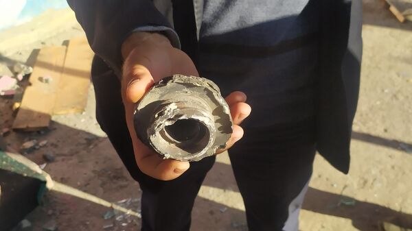 Житель села Тезакенд Агдамского района Азербайджана демонстрирует осколок снаряда после обстрела