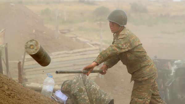 Военнослужащий стреляет из пушки по позициям вооруженных сил Азербайджана на линии соприкосновения в Нагорном Карабахе
