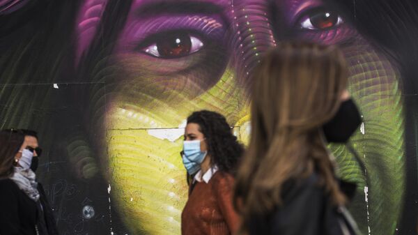 Прохожие в защитных масках на улице Гран-Виа в Мадриде