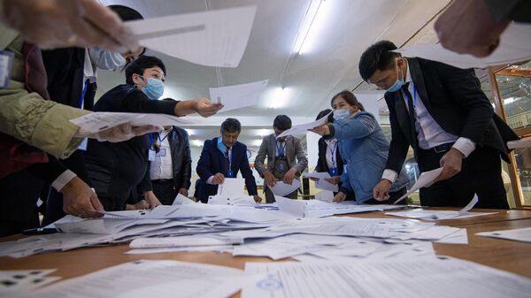 Члены участковой избирательной комиссии подсчитывают бюллетени на избирательном участке в Бишкеке
