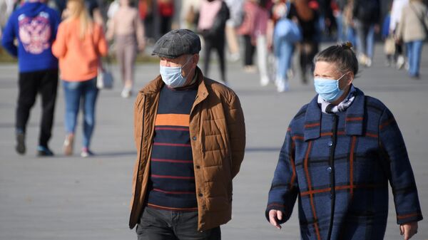 Люди в медицинских масках на территории парка ВДНХ в Москве