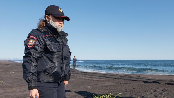 Сотрудник УМВД Камчатского края во время оперативно-разыскных мероприятий на месте предполагаемого происшествия на Халактырском пляже на Камчатке