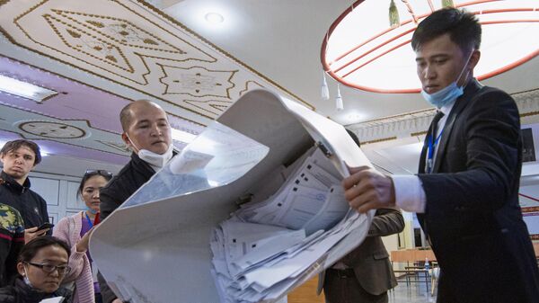 Члены участковой избирательной комиссии подсчитывают бюллетени на избирательном участке №1327 в школе-гимназии №5 в городе Бишкек