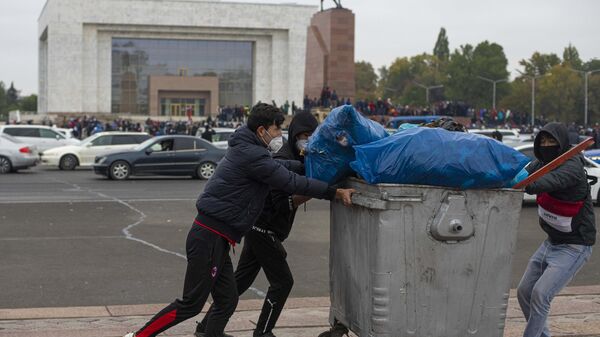 Протестующие с мусорным контейнером на центральной площади Бишкека Ала-Тоо