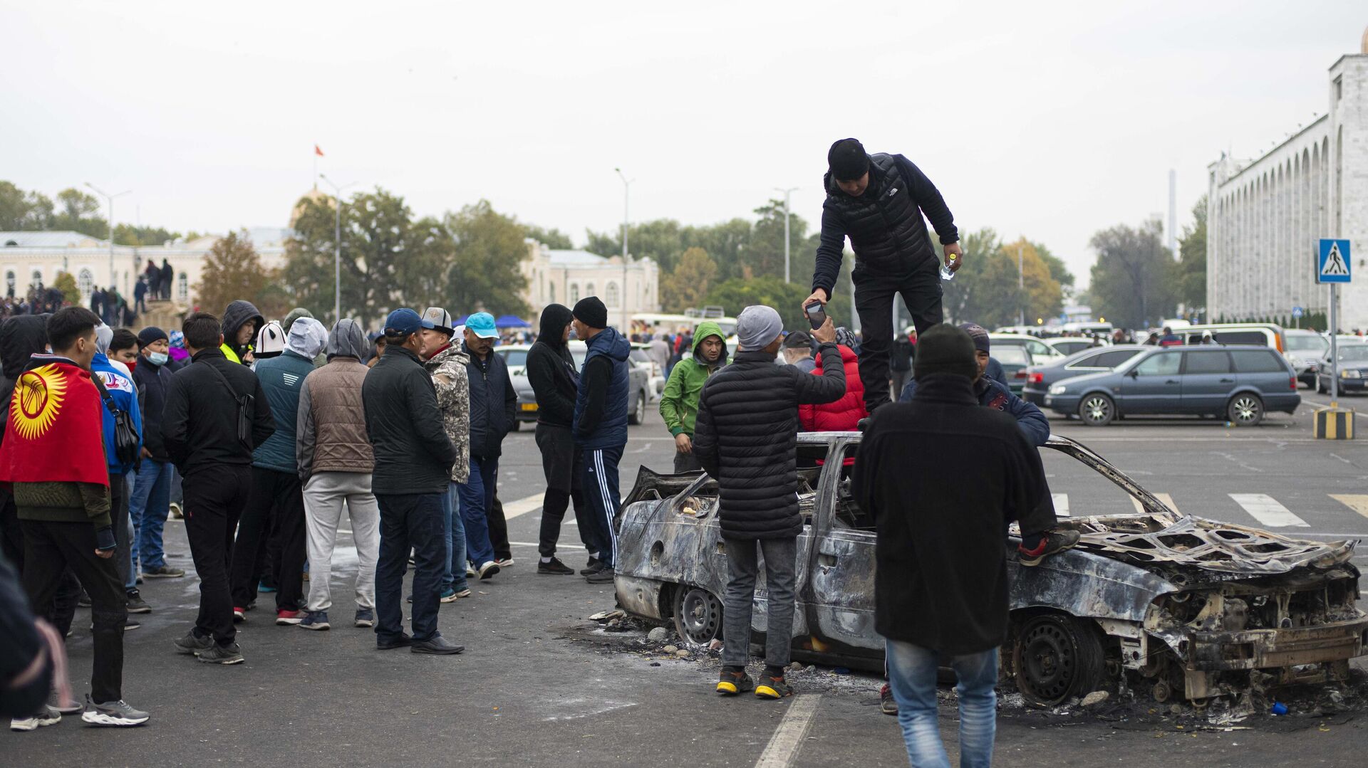 Протестующие у сожженного автомобиля на центральной площади Бишкека Ала-Тоо - РИА Новости, 1920, 06.10.2020