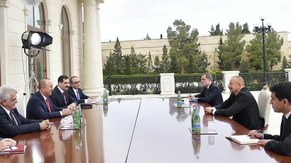 Президент Азербайджана Ильхам Алиев и глава МИД Турции Мевлют Чавушоглу (третий слева) во время азербайджанско-турецких переговоров в Баку.