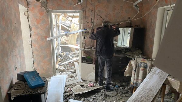 Мужчина осматривает комнату дома в Степанакерте, разрушенного после обстрела
