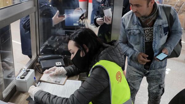 Сотрудница Московского метрополитена выписывает штраф пассажиру за несоблюдение масочного режима