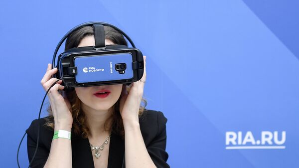 Посетительница в очках виртуальной реальности около стенда РИА Новости на ярмарке современного искусства Art Russia в Гостином дворе в Москве