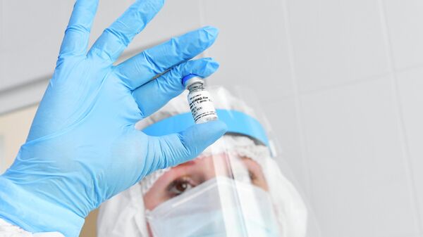 Медсестра держит в руках ампулу с вакциной Гам-Ковид-Вак