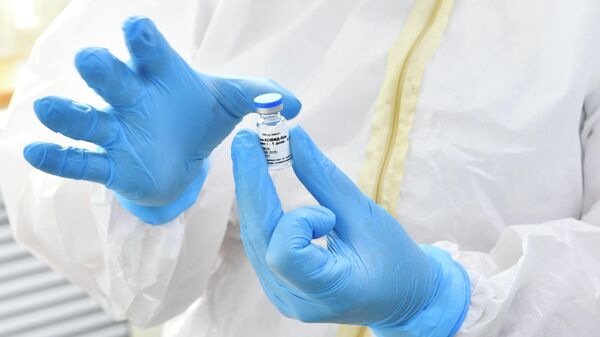 Медсестра держит в руках ампулу с вакциной Гам-Ковид-Вак 