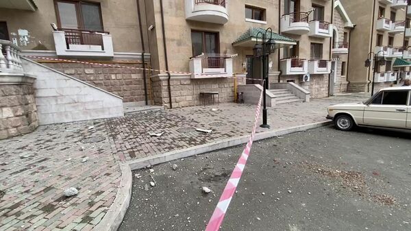 Обломки кирпича и бетона у жилого дома в центре Степанакерта, в балкон которого попала ракета системы залпового огня Смерч. Скриншот видео