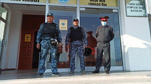Сотрудники правоохранительных органов у входа в здание мэрии в Оше