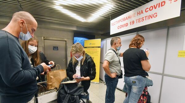 Пассажиры стоят в очереди на экспресс-тестирование на COVID-19 в международном аэропорту Внуково