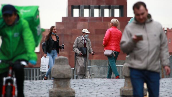 Люди в медицинских масках около Мавзолея В. И. Ленина на Красной площади в Москве