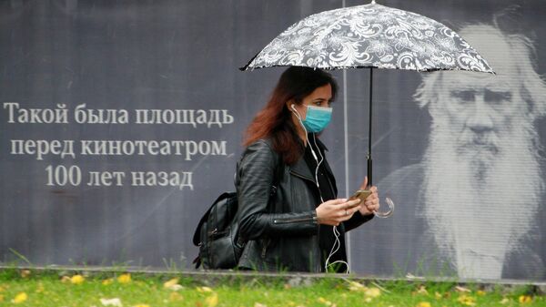 Девушка в медицинской маске на одной из улиц в Москве