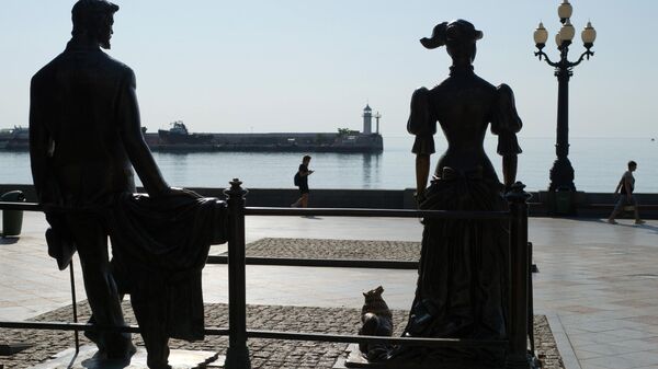 Отдыхающие у скульптуры героев рассказа А.П. Чехова Дама с собачкой на набережной Ялты