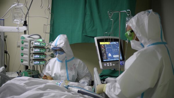 Медицинские работники оказывают помощь пациенту с COVID-19 в городской клинической больнице № 52 в Москве