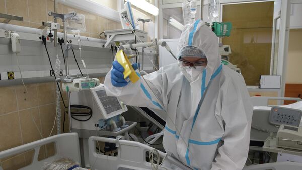 Медицинский работник оказывает помощь пациенту с COVID-19 в отделении реанимации и интенсивной терапии городской клинической больнице № 52
