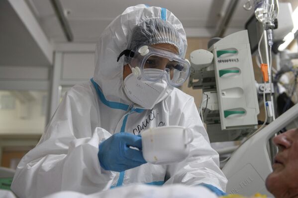 Медицинский работник оказывает помощь пациенту с COVID-19 в отделении реанимации и интенсивной терапии городской клинической больнице № 52 в Москве