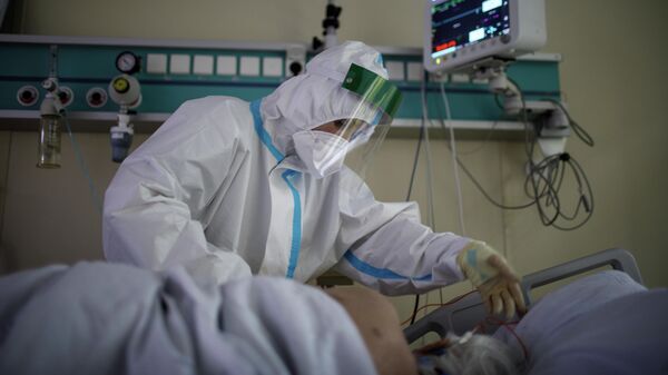 Медицинский работник оказывает помощь пациенту с COVID-19 в отделении реанимации и интенсивной терапии городской клинической больнице № 52