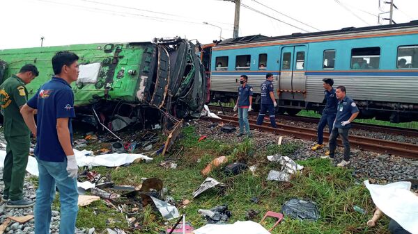 Спасатели на месте столкновения автобуса с товарным поездом в таиландской провинции Чаченгсао