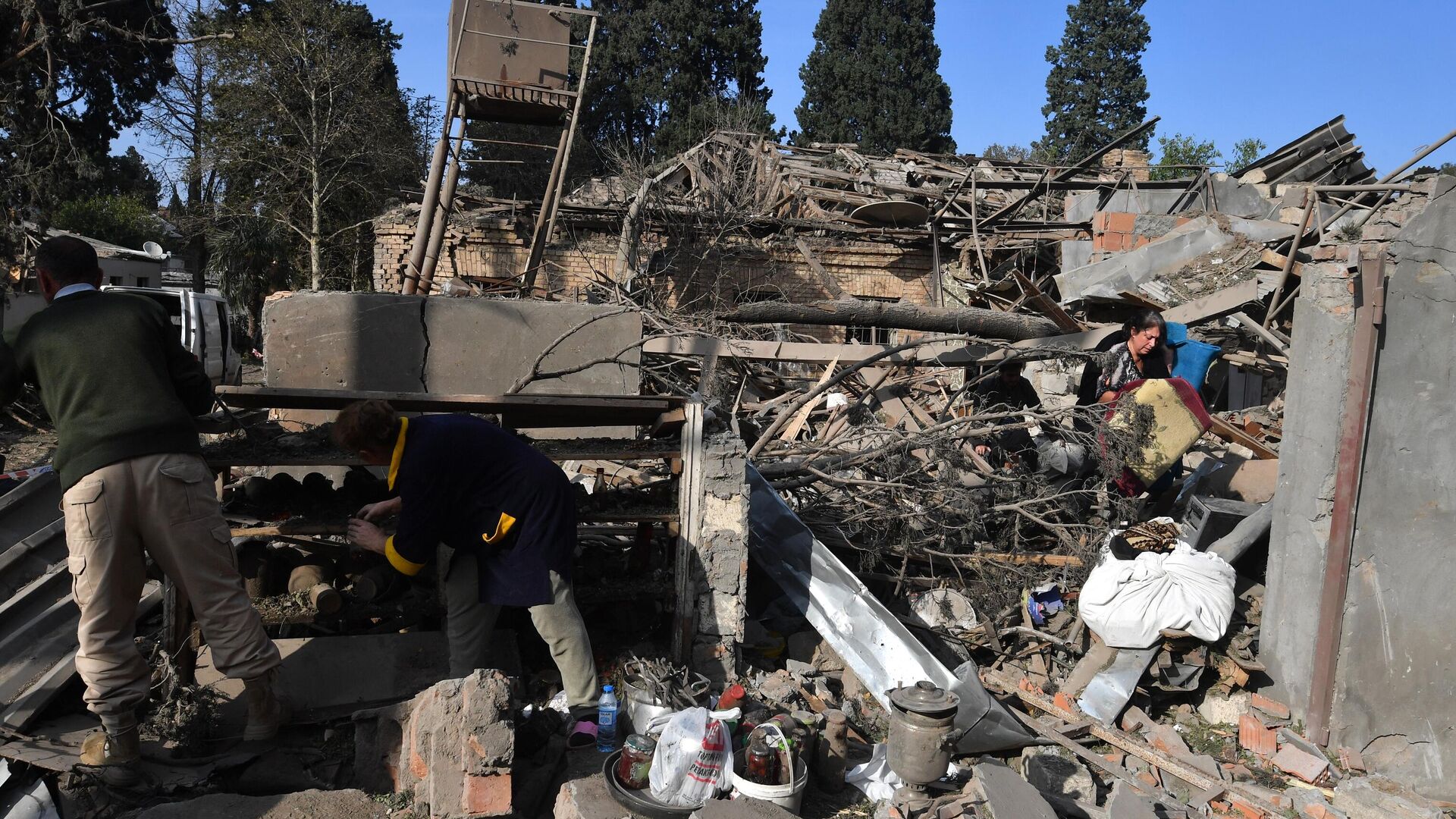 Жители собирают уцелевшие вещи на развалинах своего жилого дома, разрушенного в результате ракетного обстрела города Гянджа - РИА Новости, 1920, 11.10.2020