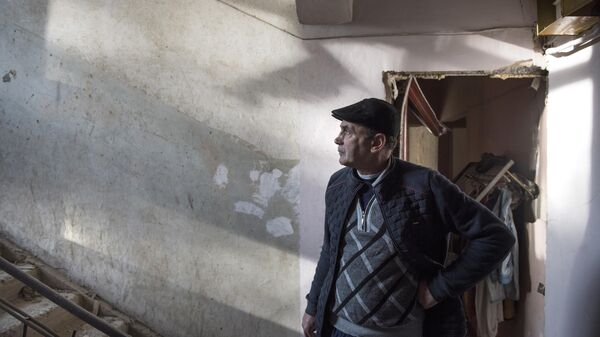 Местный житель в разрушенном доме в городе Степанакерт, который подвергся обстрелу