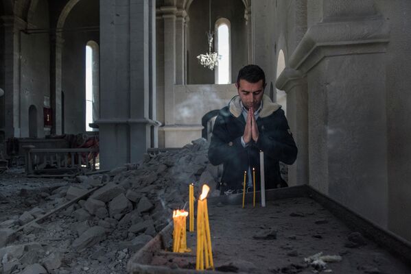 Местный житель в разрушенной обстрелом церкви в городе Шуши. Город Шуши в Карабахе подвергся обстрелу
