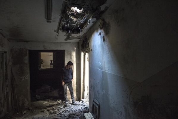 Местный житель в разрушенном доме в городе Шуши