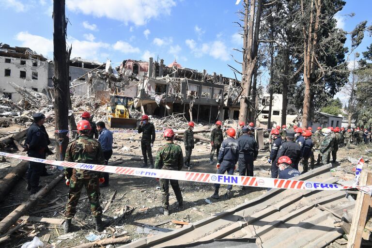 Сотрудники МЧС Азербайджана на месте разбора завалов разрушенных домов после ракетного обстрела города Гянджа