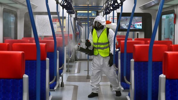 Сотрудник клининговой службы производит дезинфекционную обработку в вагоне поезда Иволга в Москве