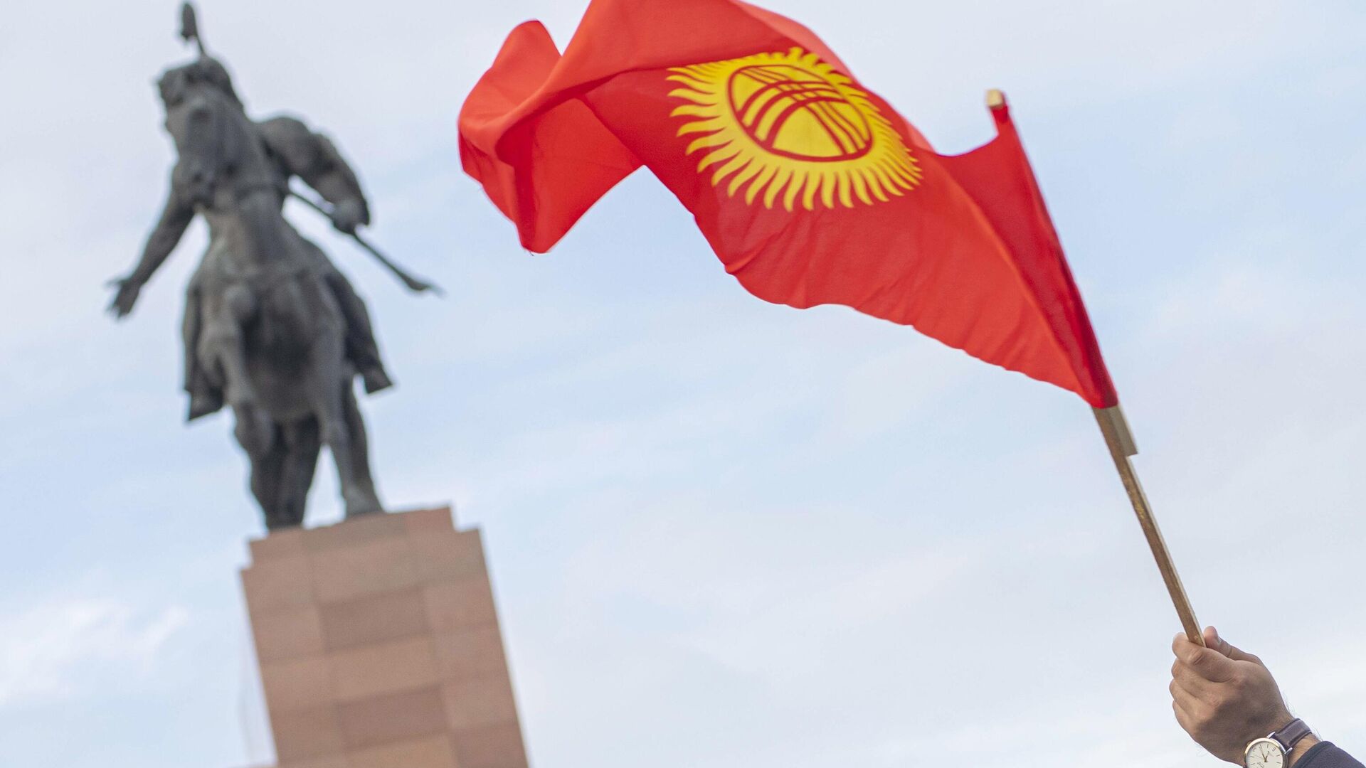 Флаг Киргизии в руке участника митинга в Бишкеке - РИА Новости, 1920, 14.10.2020