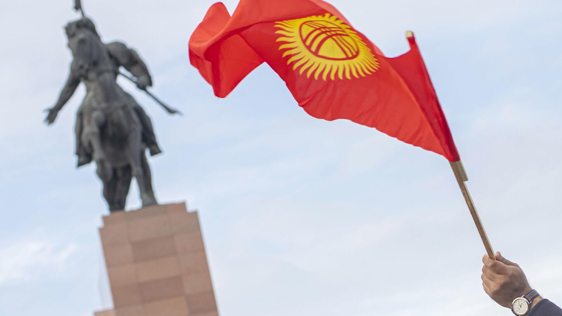 Флаг Киргизии в руке участника митинга в Бишкеке - РИА Новости, 1920, 06.07.2021