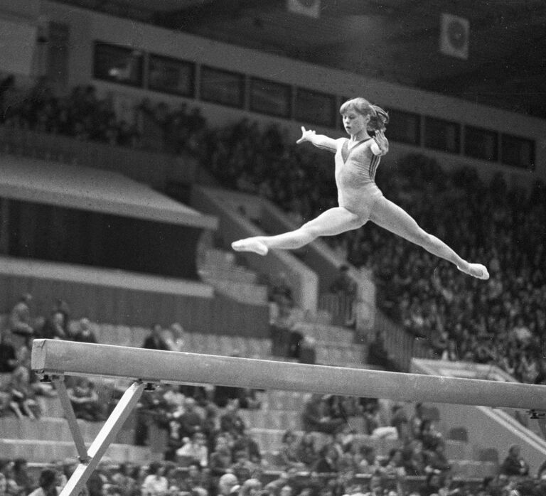 Елена Мухина выполняет упражнения на бревне.